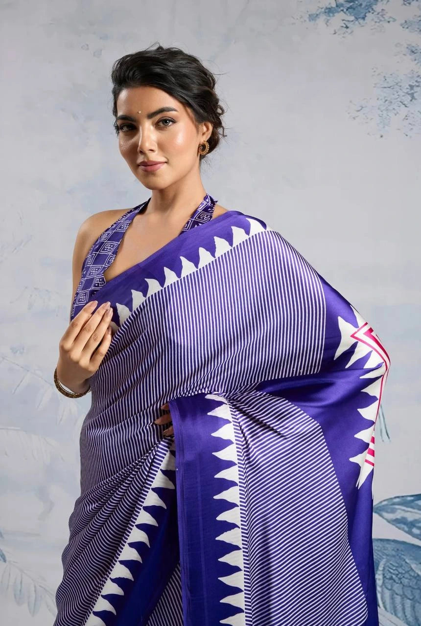 Woman wearing a purple saree with white patterns against a light gray background